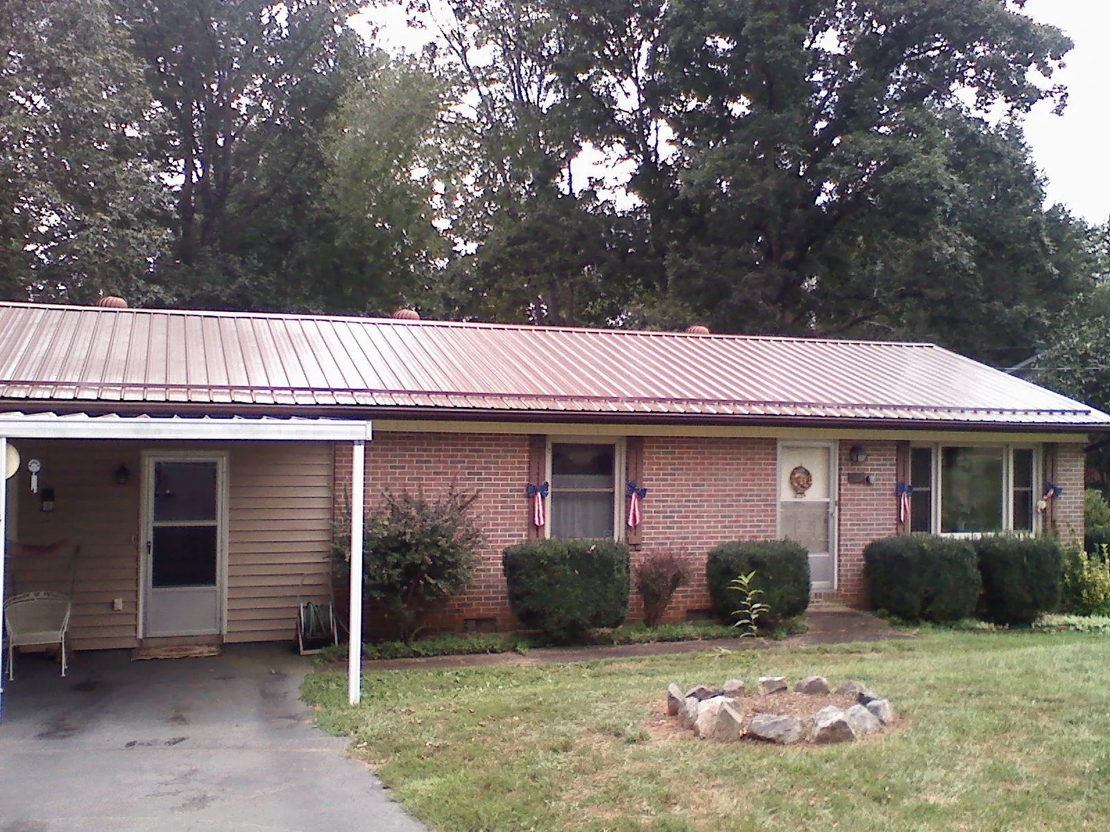 Bronze metal roof and carport on a brick ranch home — Roof Repair work by our crew in Summerton
